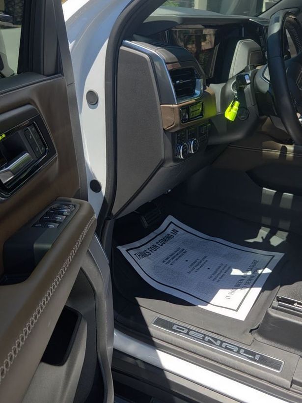 Denali driver's footwell, clean, their thank-you card on the mat