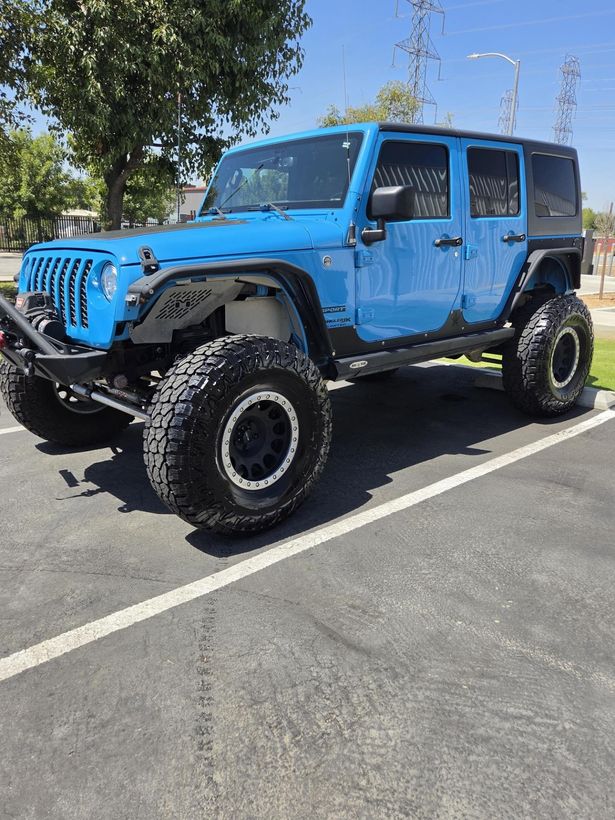 Blue lifted Jeep Wrangler after a detail, glossy in full sun