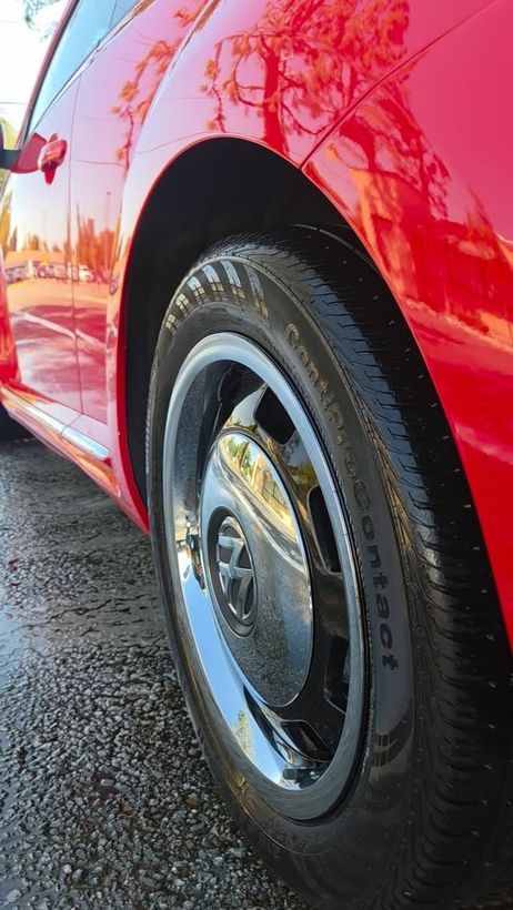 Red Volkswagen Beetle wheel and fender, wet and glossy